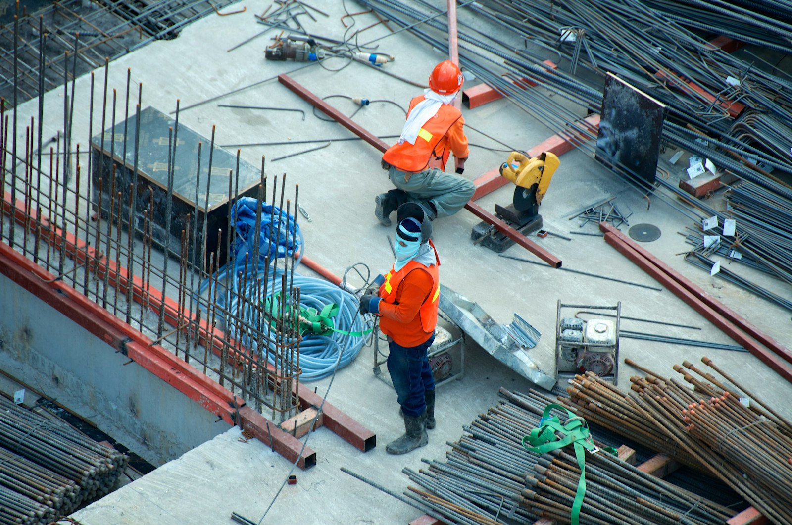 Canteiro de obras ao entardecer com equipamentos de construção, betoneiras e andaimes, paleta quente alaranjada e terrosa, fotografia realista